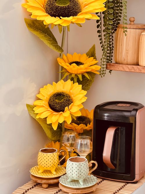Free A warm, inviting coffee setup with colorful mugs and vibrant sunflowers, perfect for relaxation. Stock Photo