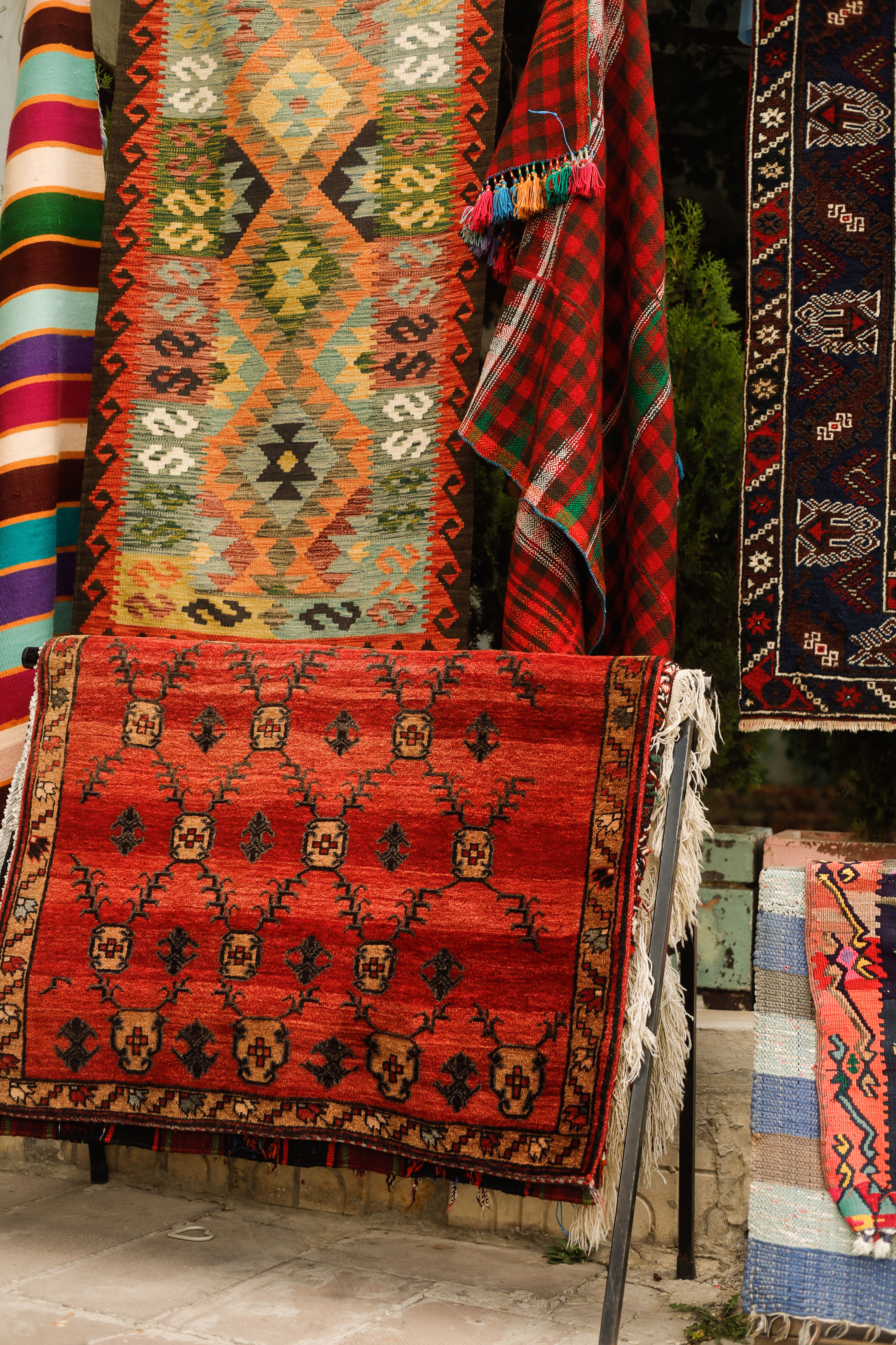 Vibrant Handwoven Rugs on Display Outdoors · Free Stock Photo