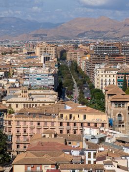 A panoramic view showcasing the historic architecture of Granada, with the Sierra Nevada mountains in the backdrop.