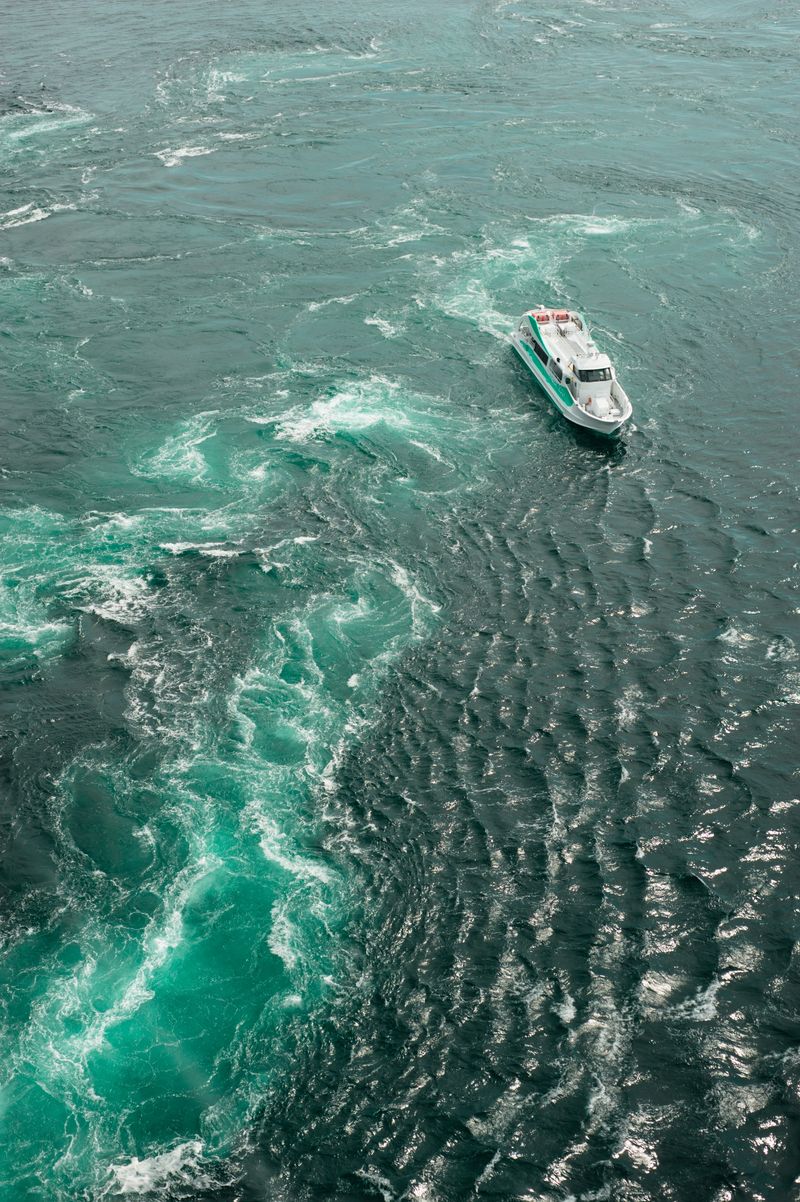 Sightseeing boat near the Naruto whirlpools — the Uzushio tour boat passes through the tidal current at peak whirlpool formation