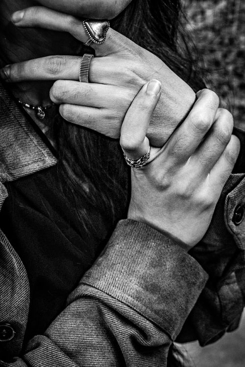 Free A detailed black and white image focusing on hands with jewelry and a coat, displaying elegance. Stock Photo