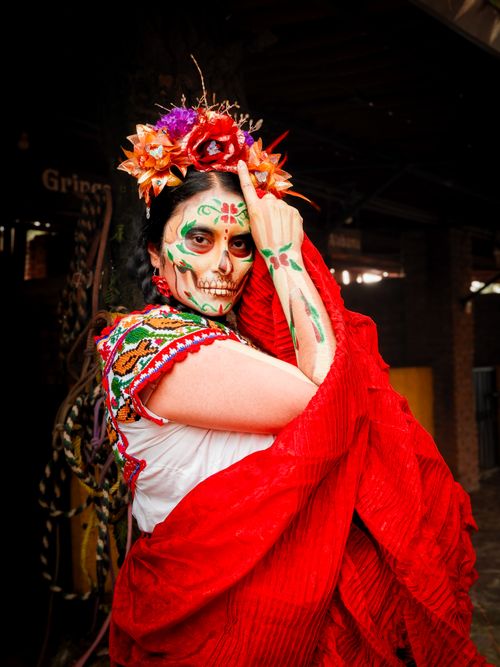 Free A woman in Catrina makeup and traditional attire celebrating Day of the Dead with colorful flower headband. Stock Photo