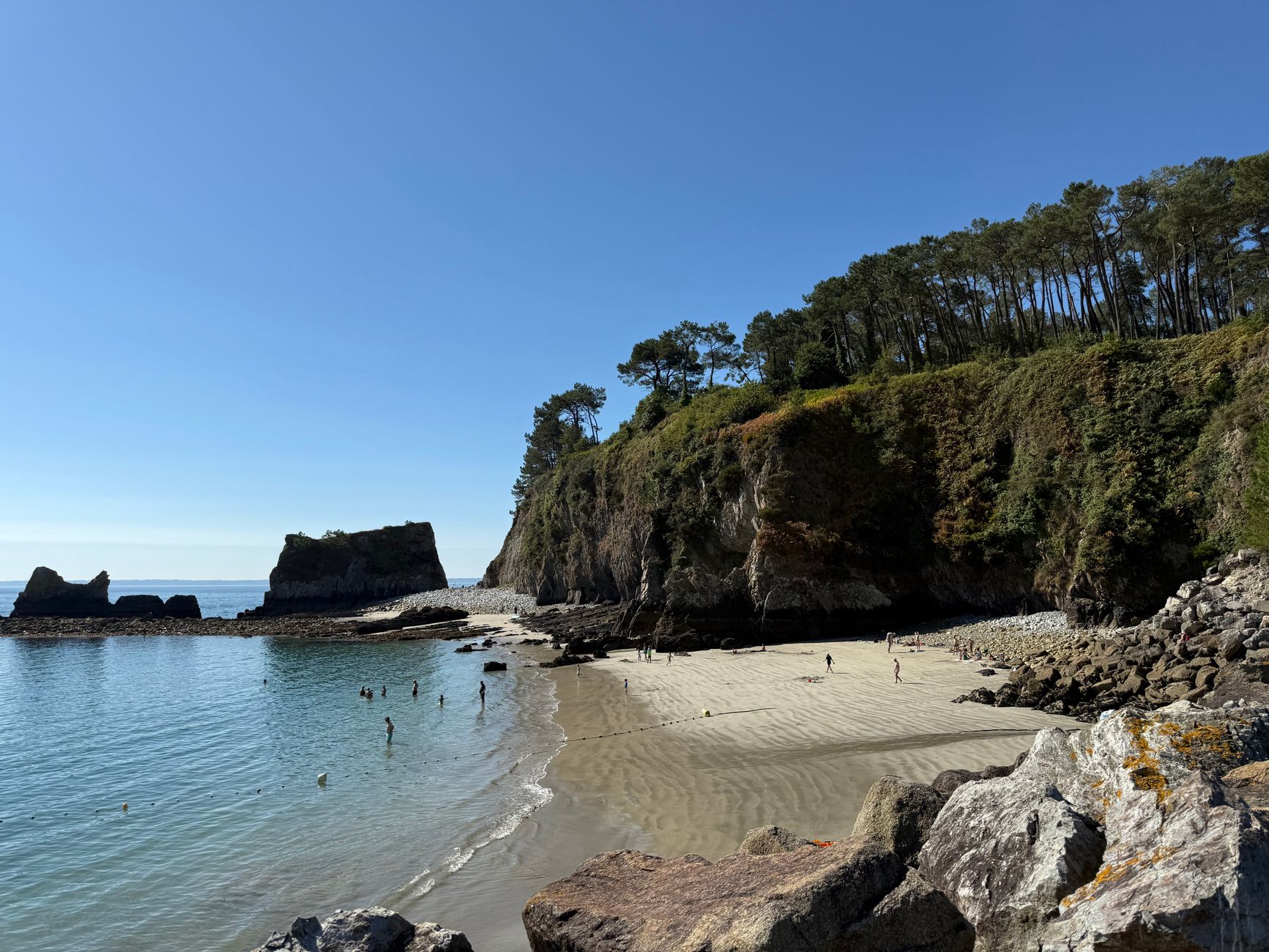 Beautiful beach with cliffs and clear blue water at Crozon Peninsula, perfect for relaxation.