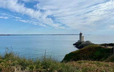 Vue imprenable sur le phare du Petit Minou surplombant l'océan calme sous un vaste ciel bleu.