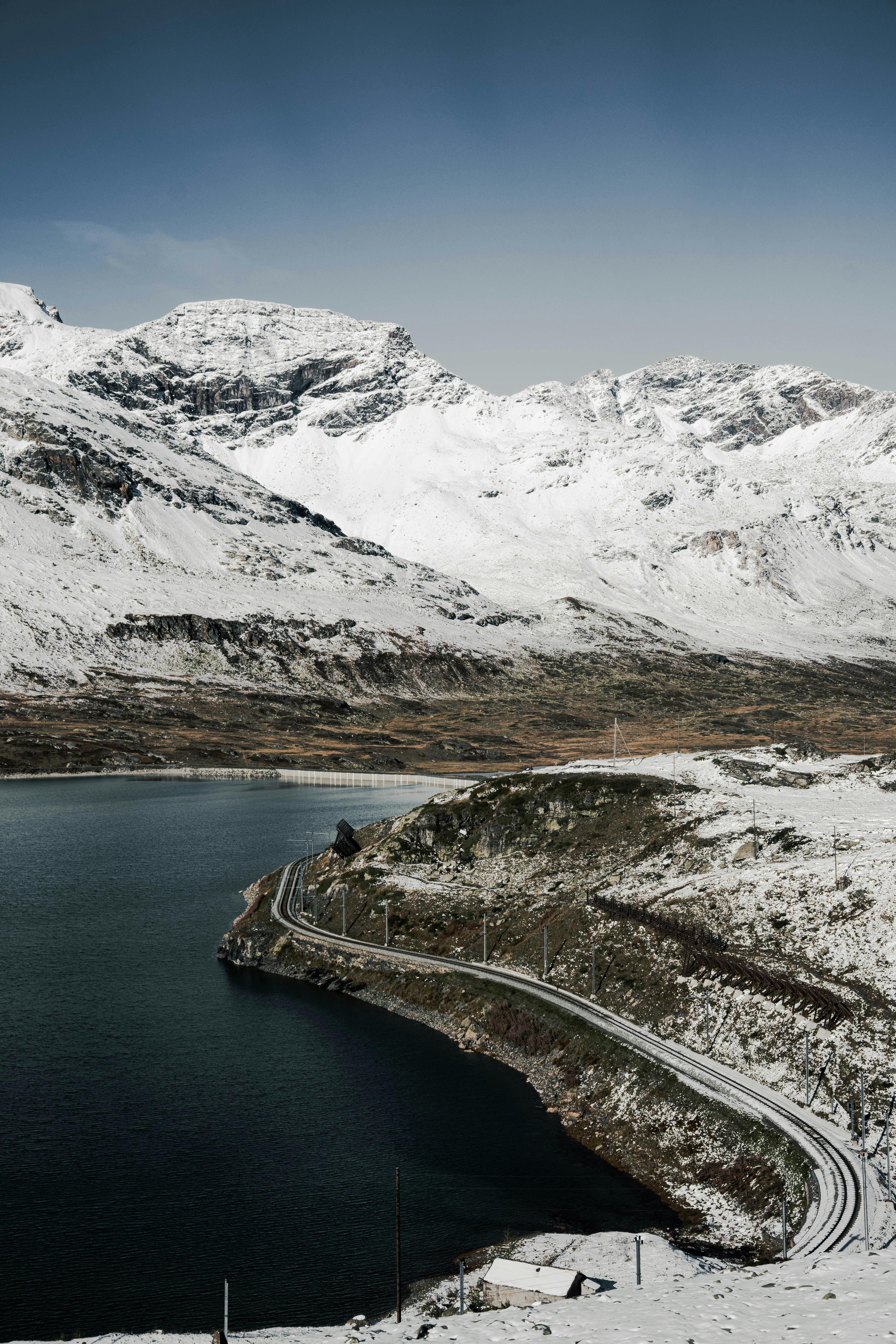 Breathtaking snow-covered mountains and lake in Poschiavo, Grisons.