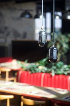 Classic hanging microphones in a sunlit cafe interior, perfect for retro vibes.