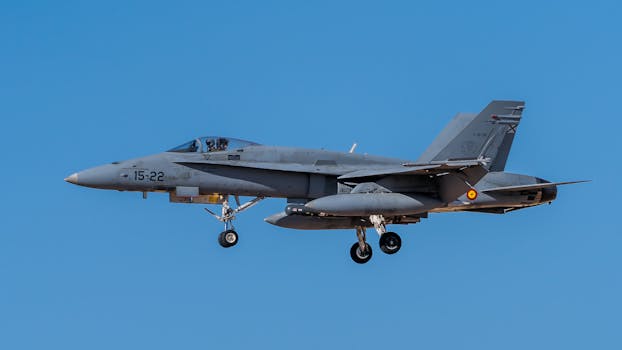 An F-18 fighter jet captured mid-flight against a clear blue sky, showcasing its impressive design and engineering.