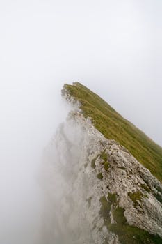 Dramatic view of a cliff shrouded in fog near Hergiswil, Nidwalden, Switzerland.