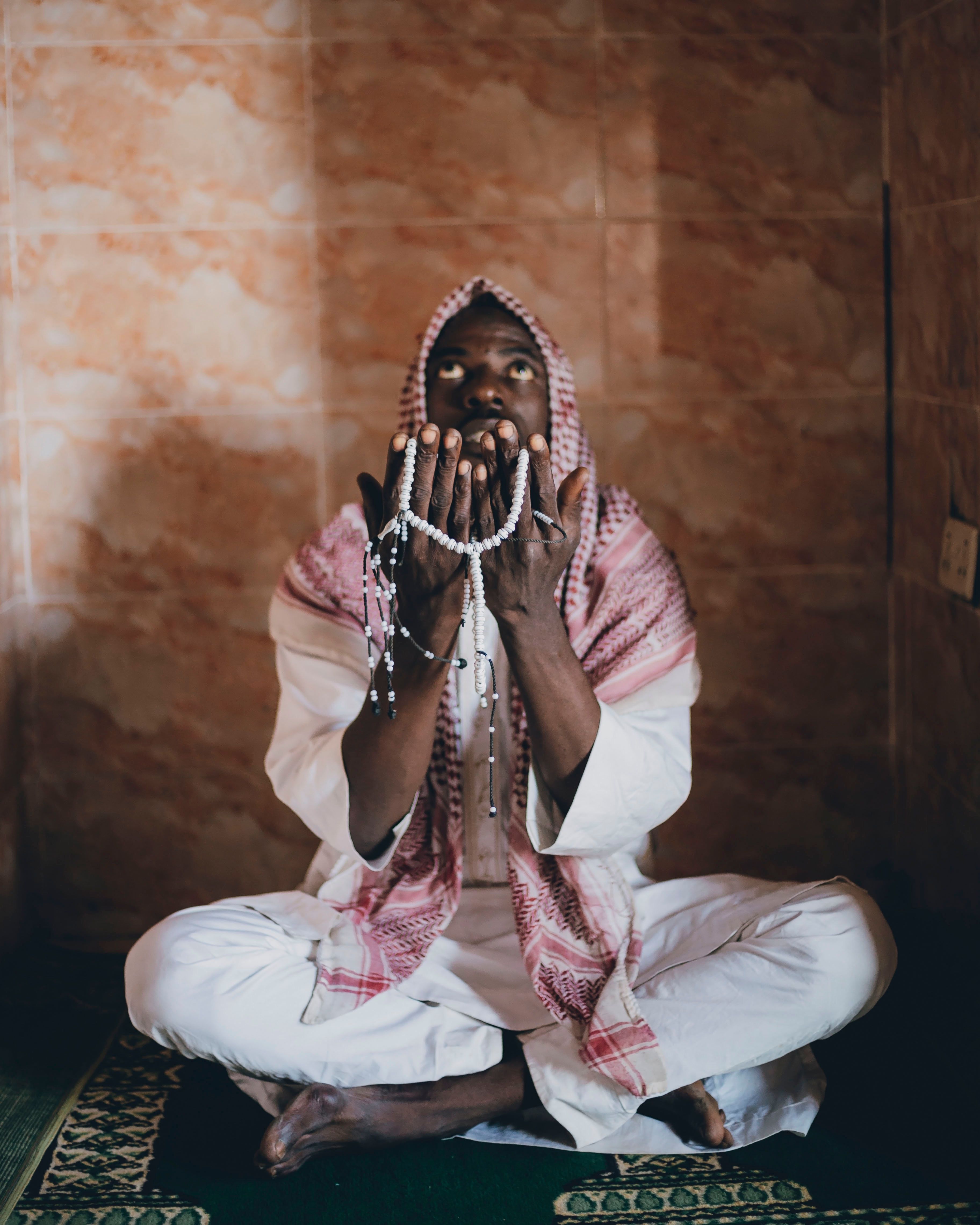 Man Praying with Prayer Beads in Traditional Dress · Free Stock Photo
