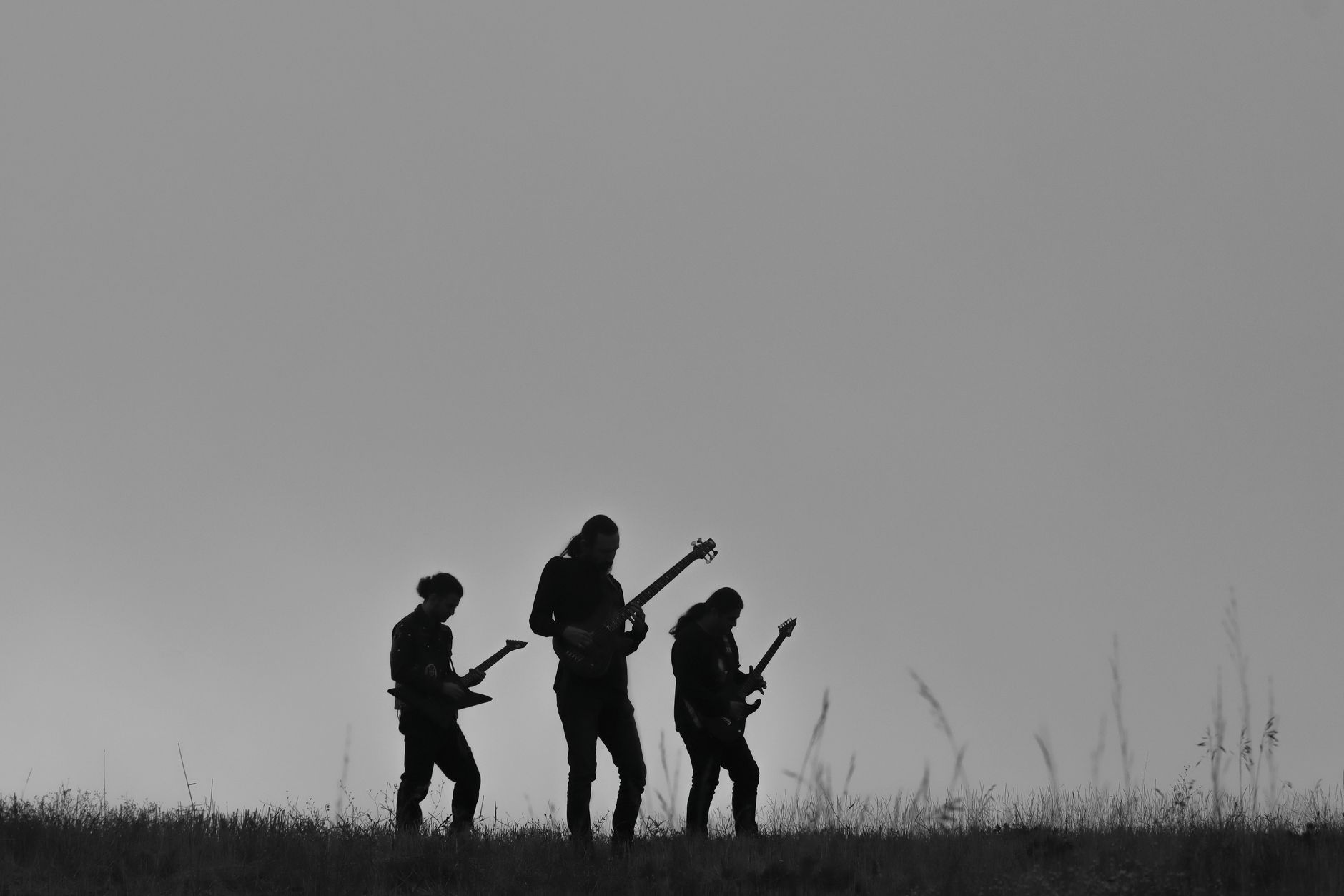 Black and white silhouette of a rock band performing in an outdoor setting in Iran.