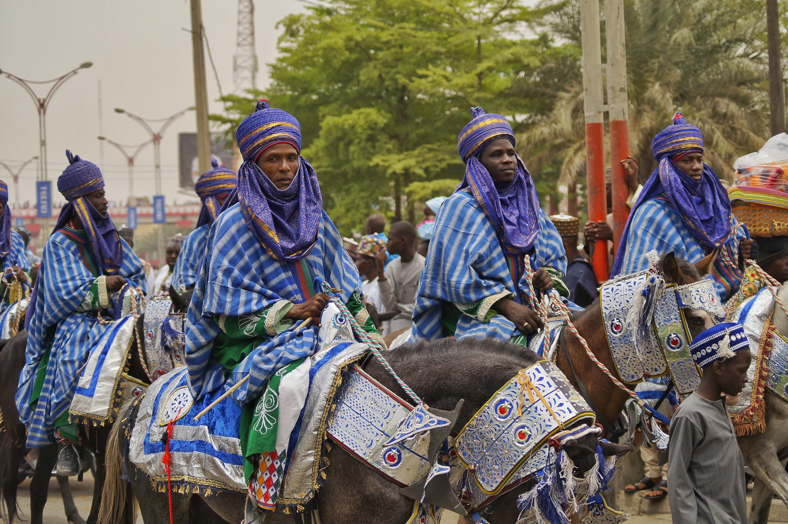 Vibrant parade of Nigerian horsemen in traditional attire showcasing cultural heritage.