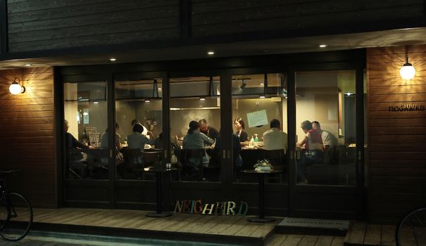 A view of people enjoying a relaxed gathering inside a modern coffee shop with wooden decor.