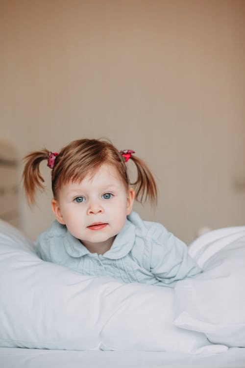 Baby Girl Wearing Green Collared Sweater on Bed