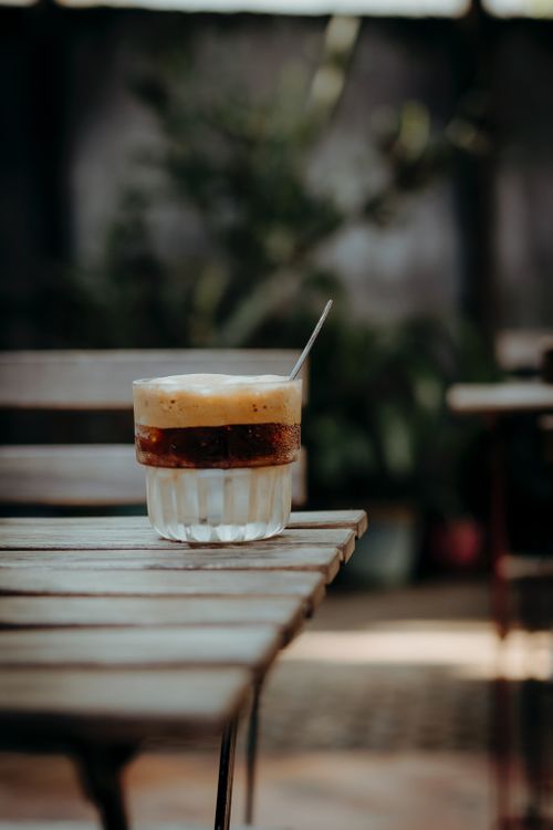 Free Moderately lit shot of espresso with cream on a wooden table outdoors. Stock Photo
