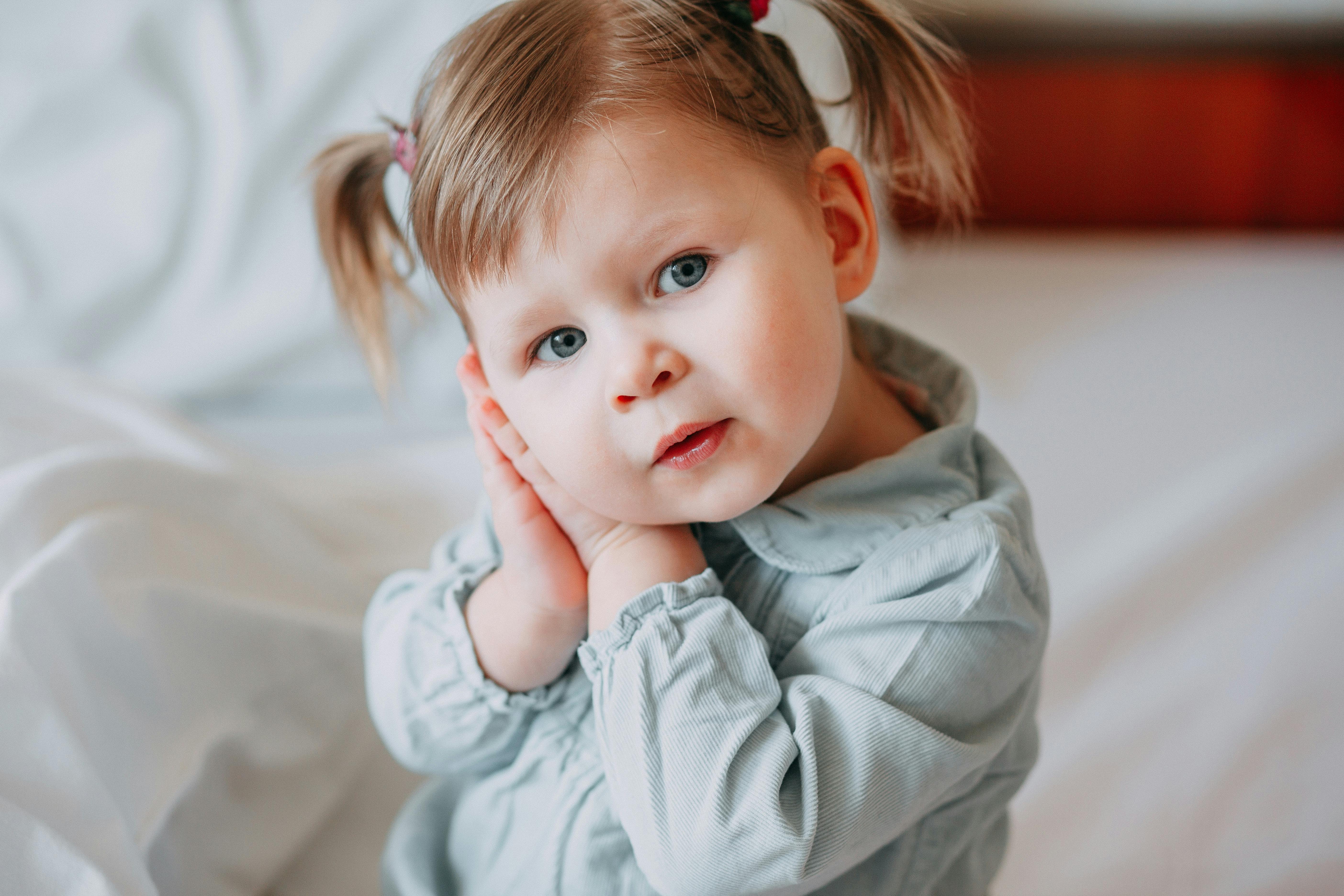 一个迷人的年轻女孩扎着马尾辫，把头靠在手上，散发着天真与平和