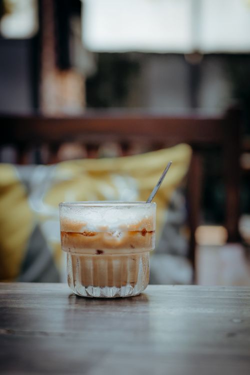 Free Close-up of iced coffee in a glass on a table in a cozy cafe setting. Stock Photo