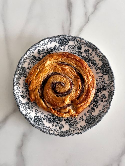 Free Delicious cinnamon swirl pastry on an ornate black and white plate. Stock Photo