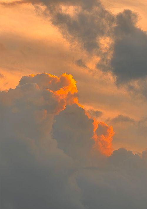 Free A stunning view of dramatic clouds illuminated by a vibrant sunset, showcasing warm and vivid colors. Stock Photo
