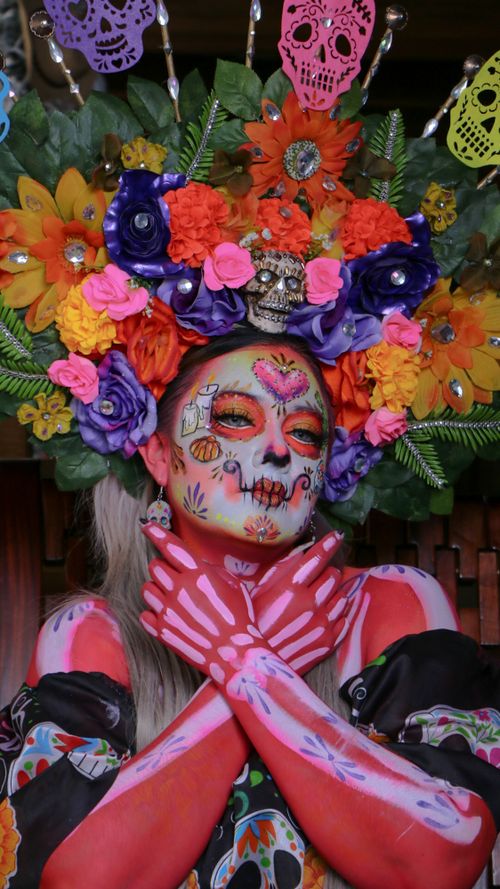 Free Colorful Day of the Dead face paint and floral headpiece capturing Mexican cultural traditions. Stock Photo