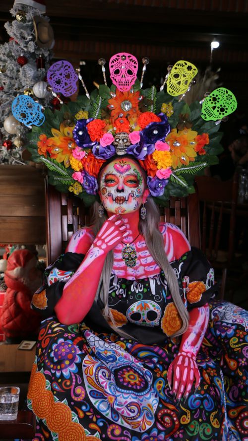 Free Colorful Day of the Dead costume with floral headpiece and face paint. Stock Photo