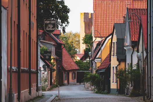 Quaint and colorful houses line a peaceful street in Visby's historic center, Gotland, Sweden.