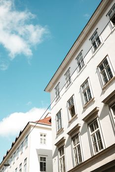 Low angle view of classic Viennese buildings under a clear blue sky, highlighting architectural elegance.