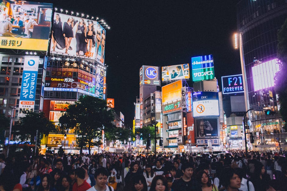 People Standing Near Buildings Under Night Sky