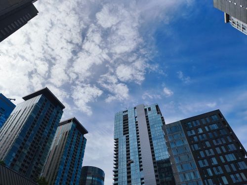 Free Urban architecture against a vivid blue sky and clouds, showcasing skyscrapers. Stock Photo