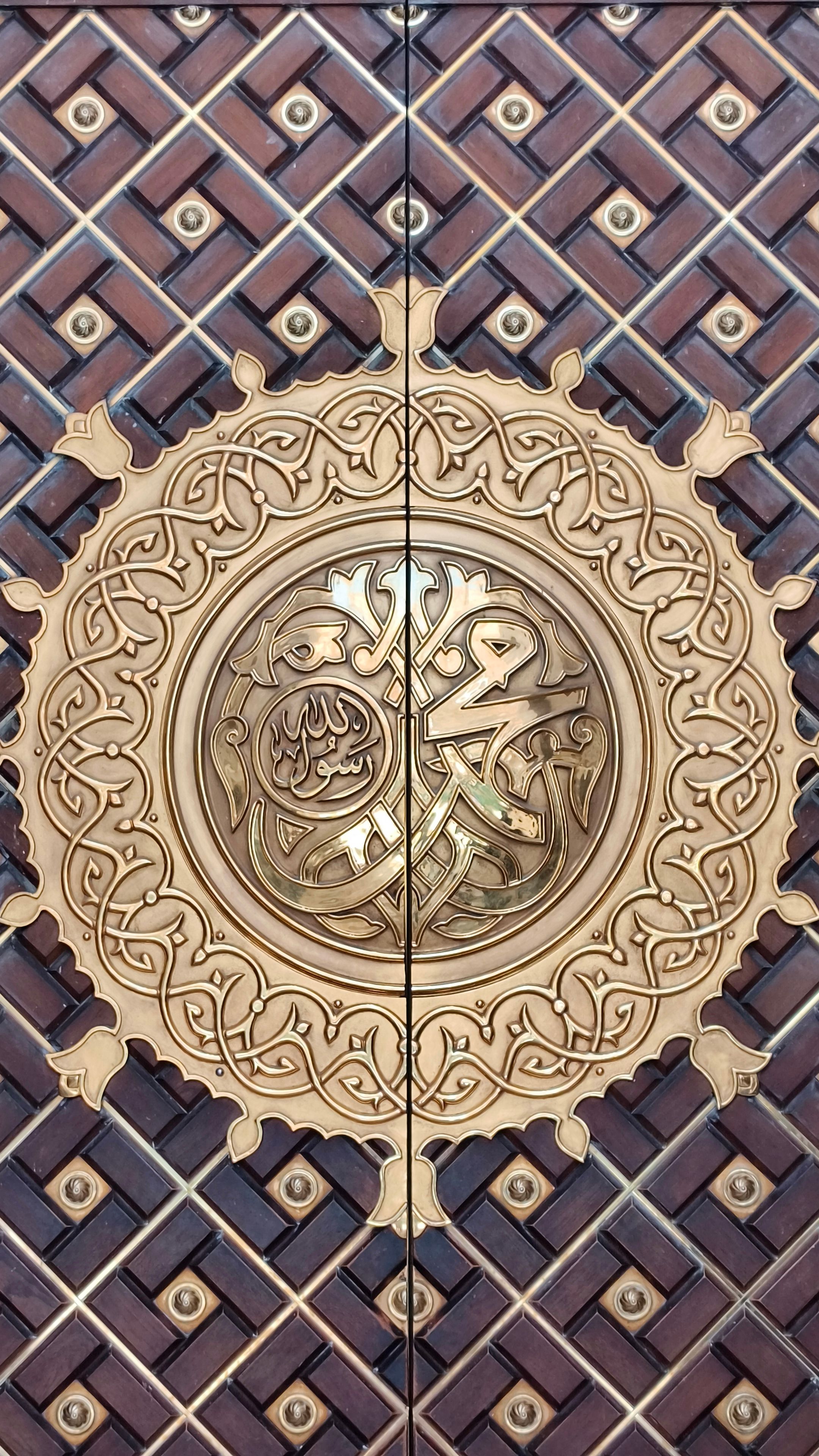 Ornate door with Islamic calligraphy and intricate arabesque designs, a beautiful example of Islamic art.
