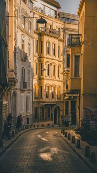 Warm sunlight illuminates a picturesque European street with historic architecture.