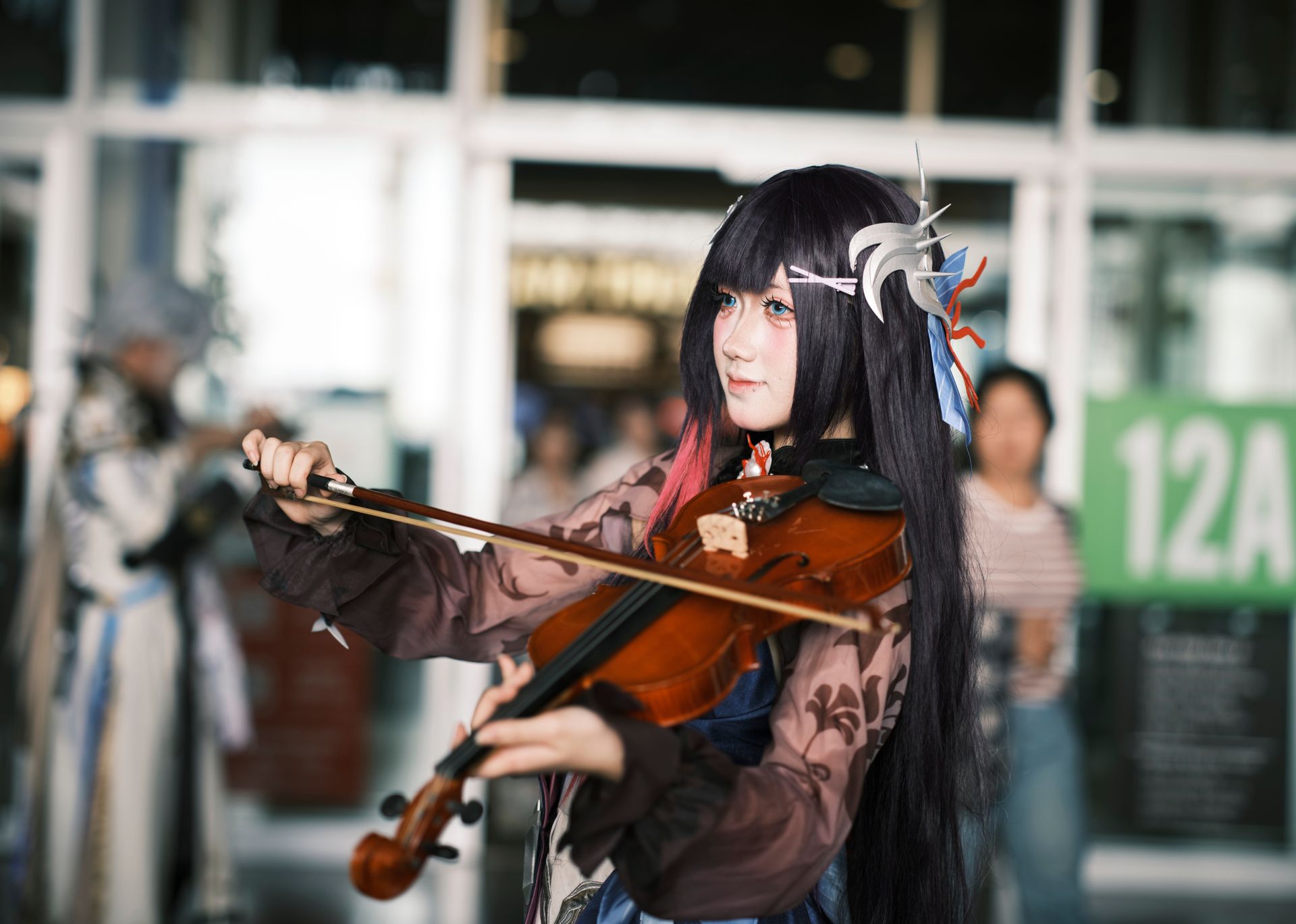 Cosplayer performing violin in an elaborate costume at an event. Focus on creativity and musical artistry.