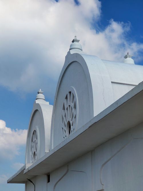 Free Close-up of a white building with ornate windows against a vivid blue sky and clouds. Stock Photo