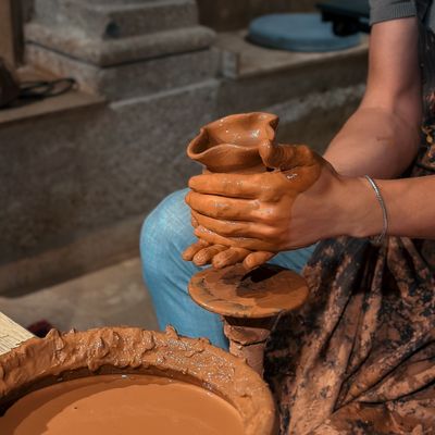 Hands shaping a clay vessel on a wheel — photo by Ugur Tandogan on Pexels