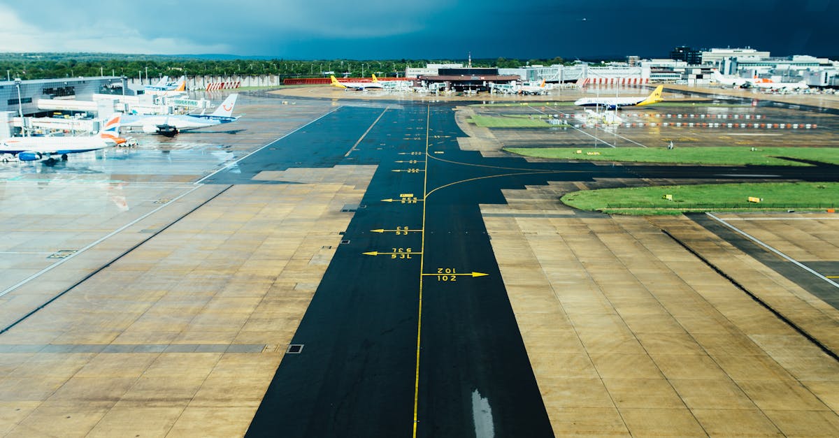 Photo by Negative Space Aerial view of an airport runway with several parked planes on a cloudy day. Ideal for travel and aviation themes.