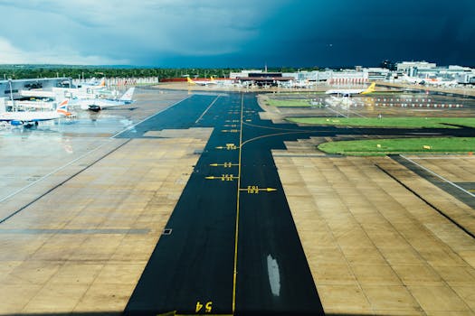 Photo by Negative Space Aerial view of an airport runway with several parked planes on a cloudy day. Ideal for travel and aviation themes.
