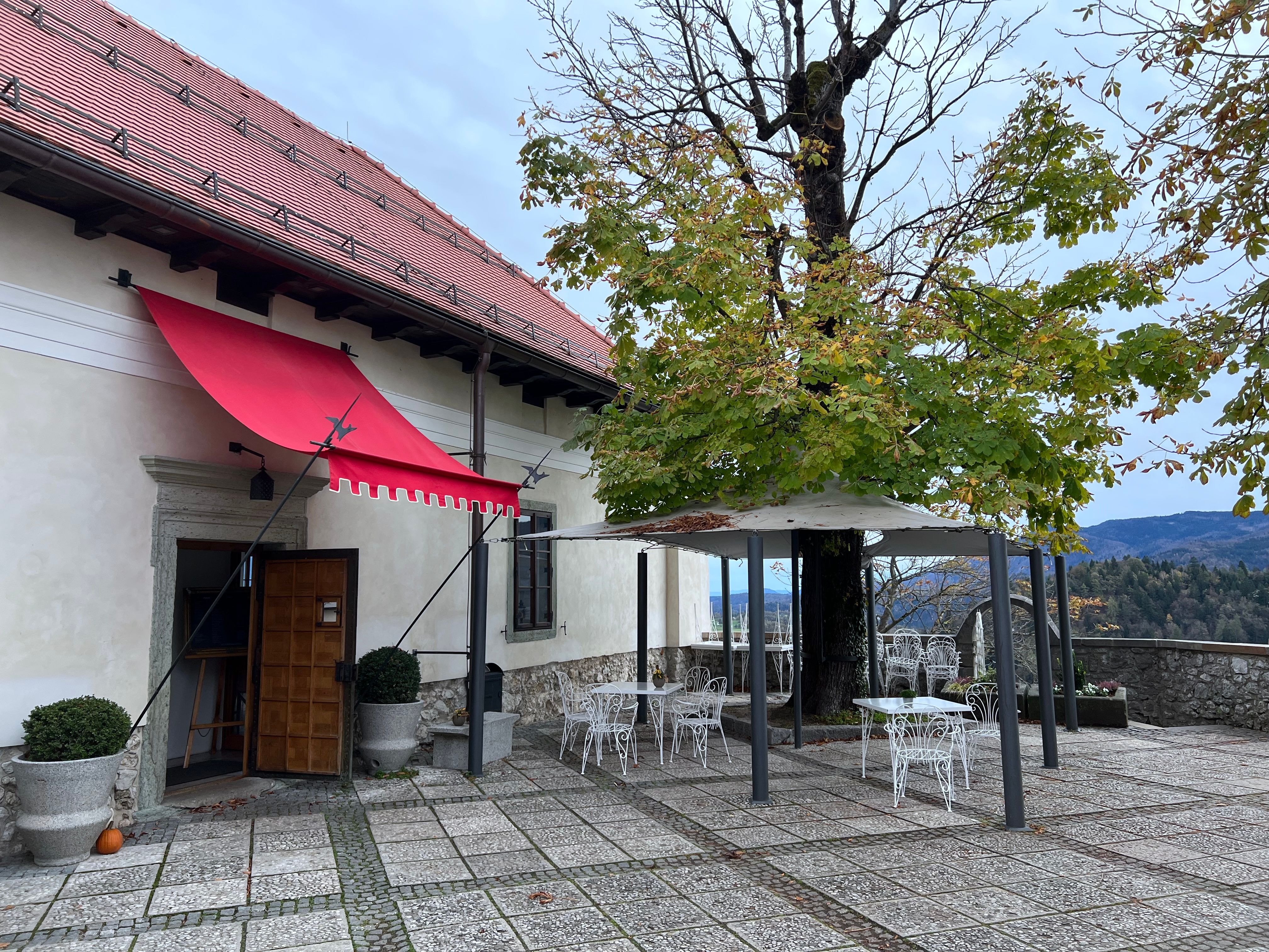 Empty cafe tables outside on a European street with autumn leaves on the ground