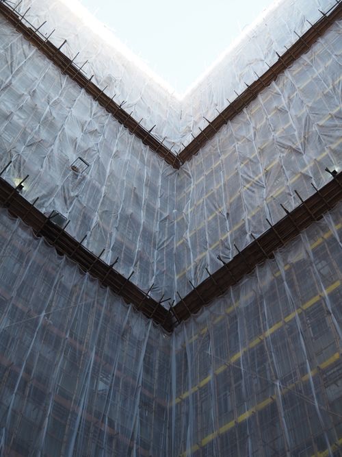 Free Photograph of a construction site in Hong Kong covered in protective netting, showcasing urban development. Stock Photo