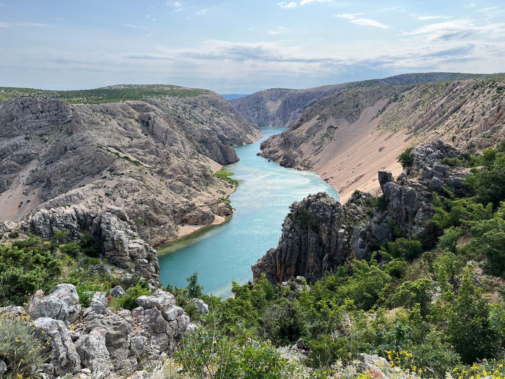 A breathtaking view of a canyon with a winding river under a clear blue sky.