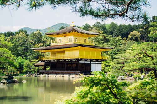 Free Scenic view of Kinkaku-ji, the Golden Pavilion, surrounded by lush greenery and a tranquil pond in Kyoto, Japan. Stock Photo