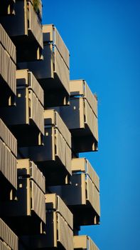 Detailed view of geometric balconies against a blue sky in Bari, Italy.