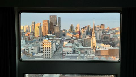 A beautiful city skyline view from a hotel room, framed by a large window.
