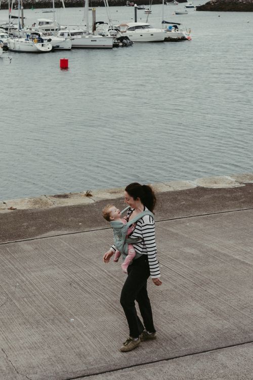 Free A mother walks with her baby at Dublin Harbor, showcasing serene waterfront views. Stock Photo