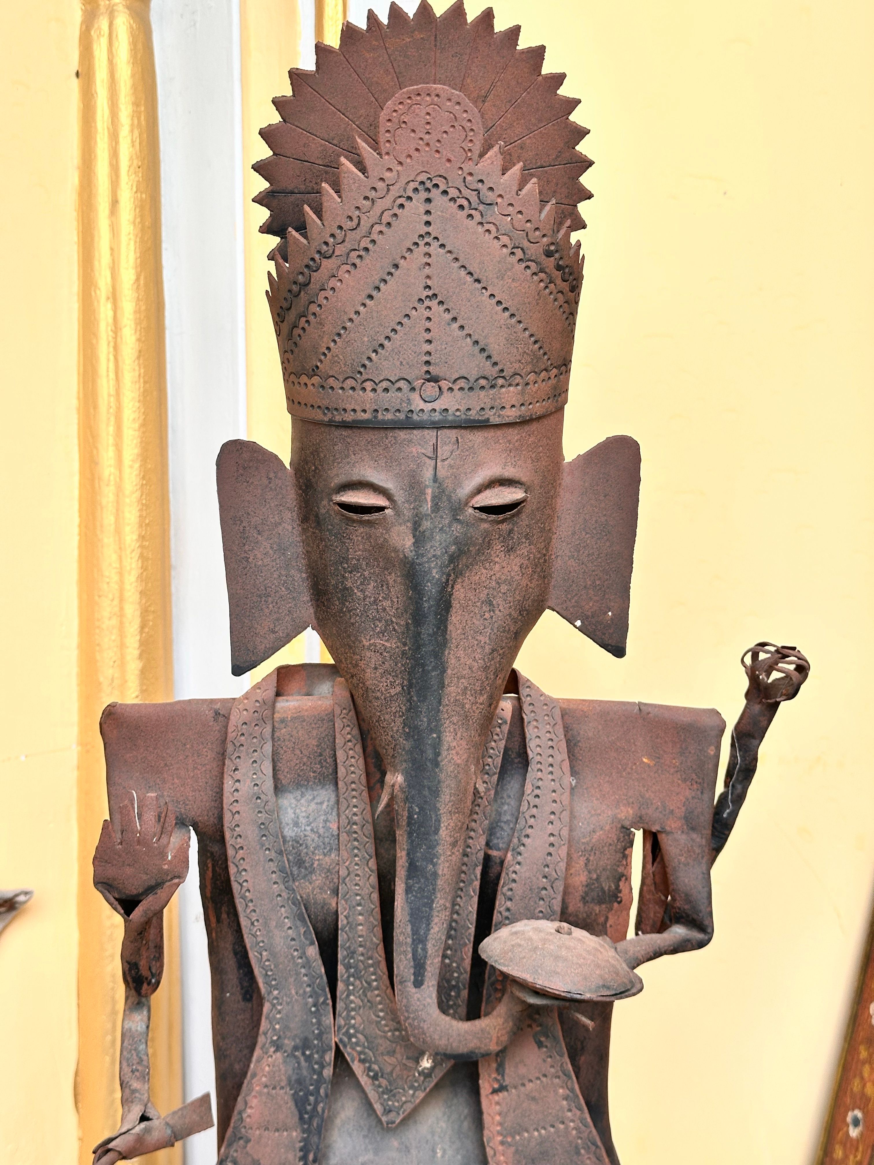 Artistic metal sculpture of an elephant deity with intricate details.