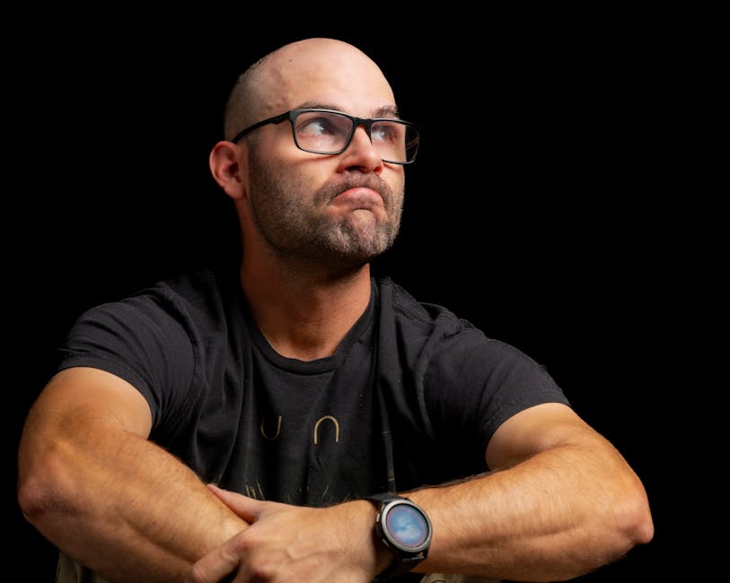 Samsung Galaxy Watch 7 vs Google Pixel Watch 3: Android Fitness Face-off (2024) Thoughtful man with glasses in a dark setting, displaying a contemplative expression. Ideal for lifestyle imagery.