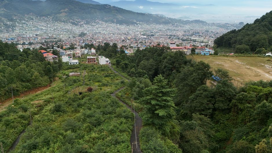 Amazing Everest Base Camp Flight Over by Helicopter from Kathmandu Review 2026 - Aerial view of lush greenery leading to the bustling Kathmandu Valley cityscape.
