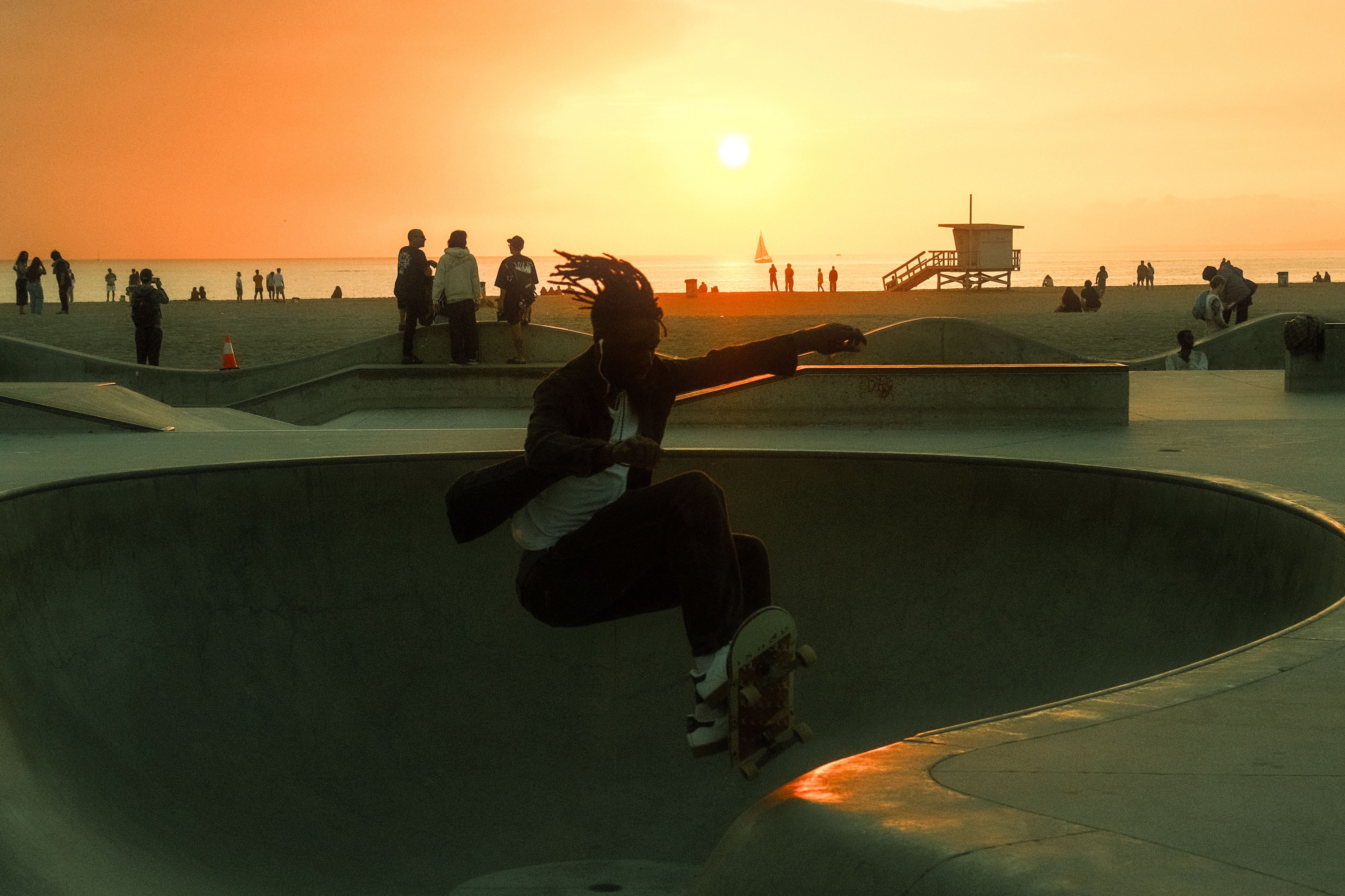 A skateboarder in action silhouetted against a stunning Venice Beach sunset, capturing a vibrant Los Angeles vibe.