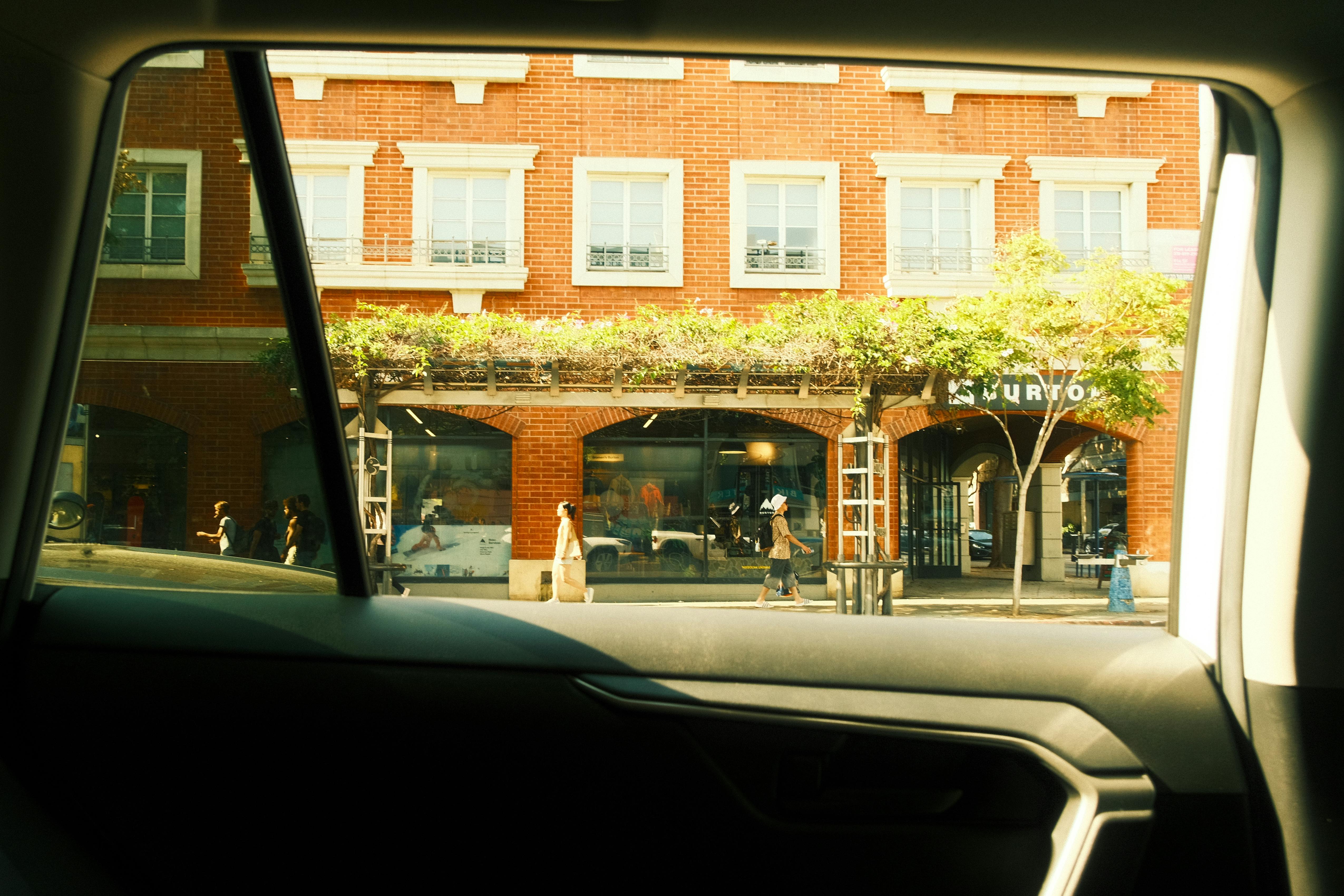 Ücretsiz Los Angeles'ta bir şehrin sokaklarından bir arabanın penceresinden görünen, günlük yaşamı yansıtan fotoğraf. Stok Fotoğraflar