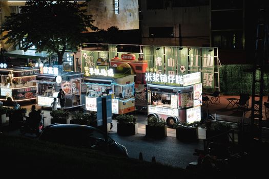Illuminated street food stalls at night in Foshan, China, creating a vibrant market atmosphere.