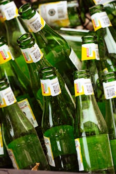 Collection of recyclable green glass bottles in a container, emphasizing sustainability.