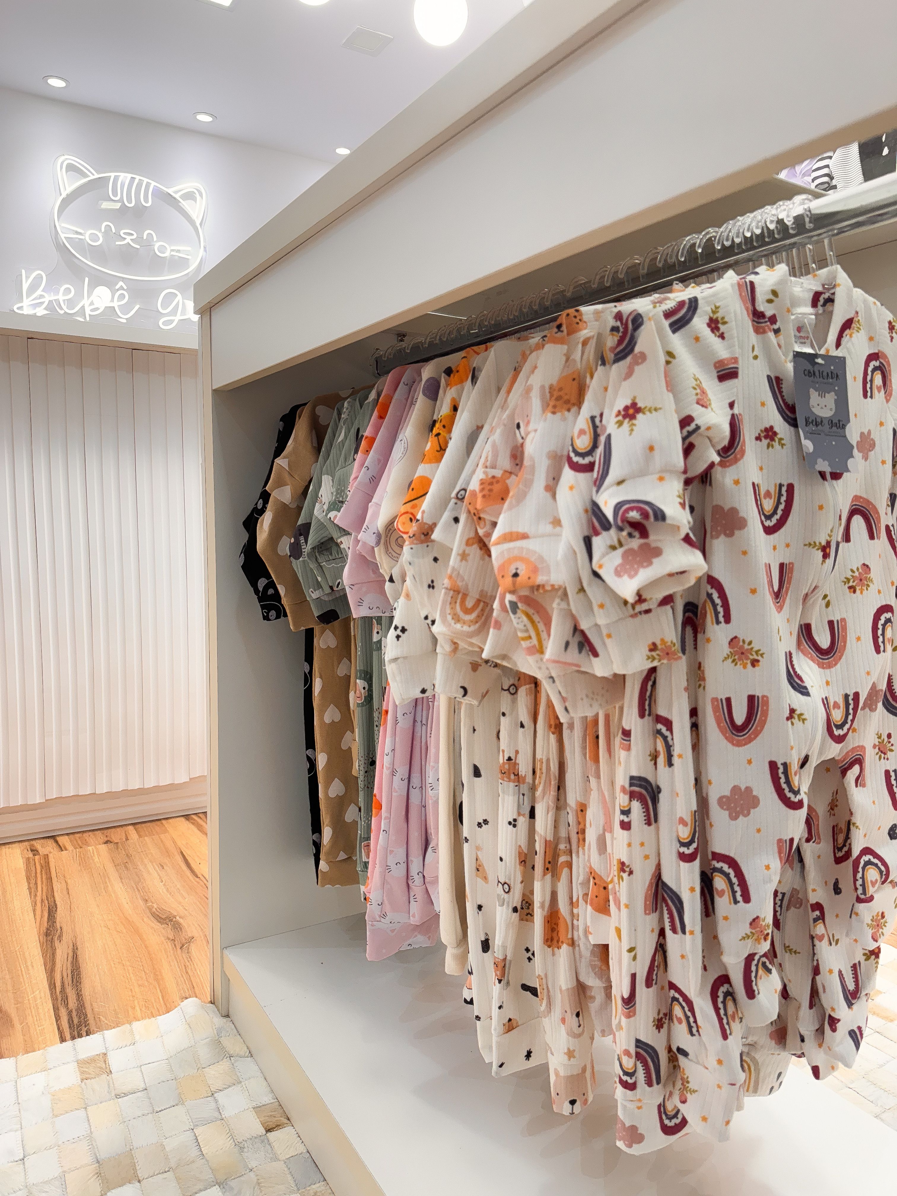 Exposição encantadora de roupas coloridas de bebê em um ambiente moderno de loja de varejo.